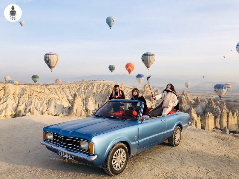 รถคลาสสิคถ่ายรูปกับบอลลูนยามเช้าใน Cappadocia