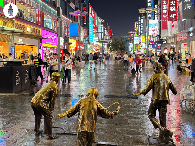 ถนนคนเดินหวงซิงลู่ยามค่ำคืน แสงไฟและผู้คนคึกคัก