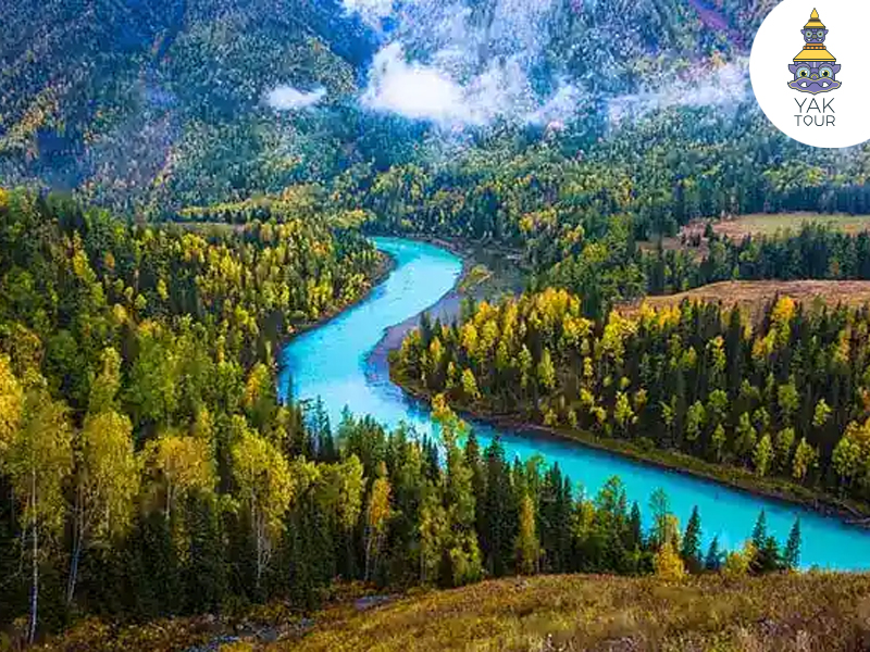 ทะเลสาบคานาสือในฤดูร้อน น้ำสีฟ้าอมเขียวกลางภูเขาและป่าสนในซินเจียง